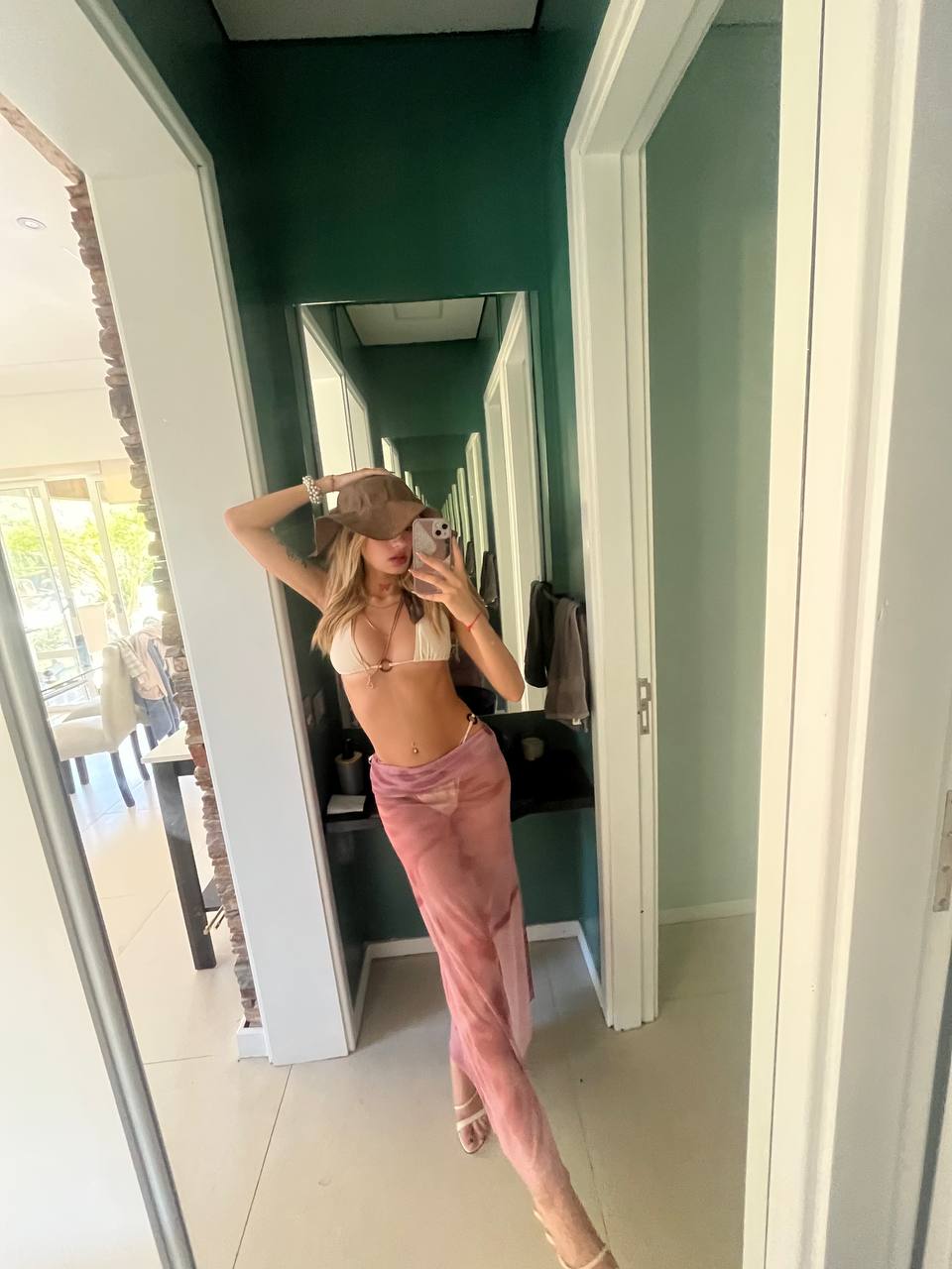 Mirror portrait wearing a cap and pink skirt.